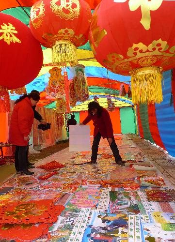 People select Spring Festival decorations on a street in Dafeng, east China's Jiangsu Province, Feb. 12, 2010.