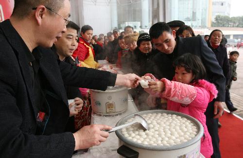 A girl receives free Tangyuan, or stuffed dumplings, at the Chengdu Lantern Festival Trade Fair in Chengdu, capital of southwest China's Sichuan province, Feb. 20, 2010. 