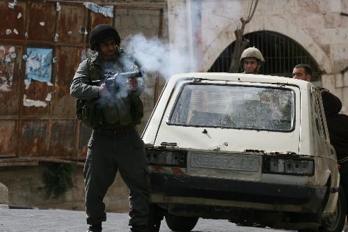 An Israeli soldier fires a tear gas canister at protestors during a demonstration in the West Bank city of Hebron, on Feb. 22, 2010. 