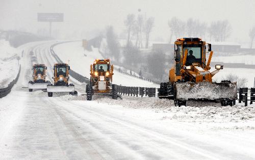 Snow removers clear snow at Harbin-Tongjiang Road near Harbin, capital of northeast China's Heilongjiang Province, Feb. 24, 2010. Most regions in Heilongjiang witnessed heavy snow since late Feb. 23 and three of five expressways in the province have been closed.
