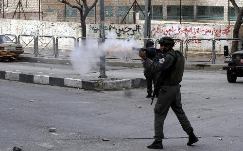 An Israeli soldier fires tear gas at Palestinian protesters during clashes in the West Bank city of Hebron, Feb. 24, 2010. 