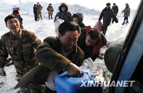 Staff members load rescue materials onto a helicopter in Xinjiang, where at least seven people were killed and more than 400 others were trapped by two avalanches on Thursday, February 25, 2010.