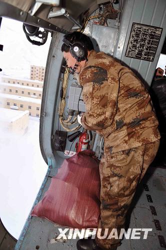 A soldier drops materials from a helicopter to people trapped by avalanches in Xinjiang on Thursday, February 25, 2010.