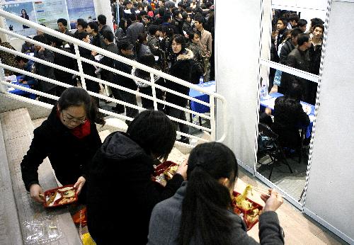 Job seekers have their food at a job fair held in Shanghai, China, Feb. 27, 2010. 