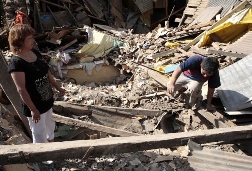Chileans gather belongings at destroyed buildings in Santiago, Chile, Feb. 28, 2010. 