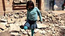 A Chilean girl walks past a destroyed building in Santiago, Chile, Feb. 28, 2009.