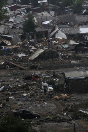 People search for things among debris in earthquake-and-tsunami-devastated Dichato town, some 30 kilometers north of Concepcion, Chile, March 1, 2010. 
