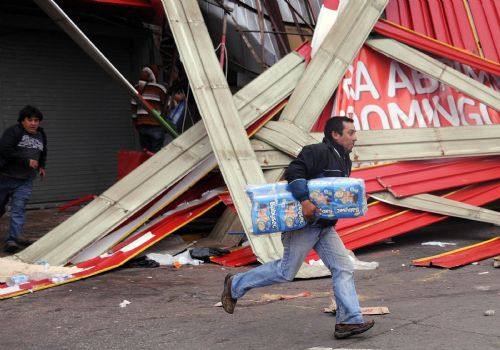 A looter runs away with merchandise he stole from a shop in the quake-devastated Concepcion, Chile, March 1, 2010. 