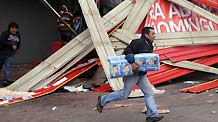 A looter runs away with merchandise he stole from a shop in the quake-devastated Concepcion, Chile, March 1, 2010.