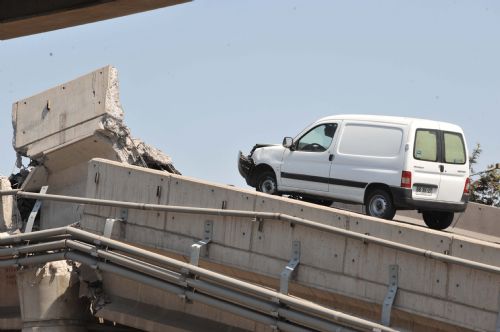 A car sits on a collapsed bridge in the northern suburb of Santiago, capital of Chile, March 1, 2010. 