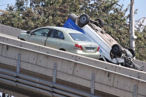Two cars sit on a collapsed bridge in the northern suburb of Santiago, capital of Chile, March 1, 2010. 