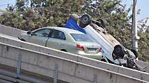 Two cars sit on a collapsed bridge in the northern suburb of Santiago, capital of Chile, March 1, 2010.