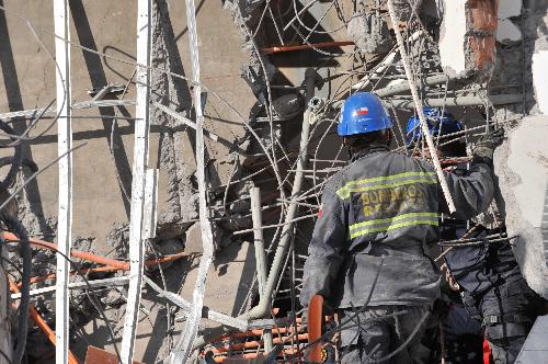Rescuers are busy on the site of a collapsed building in Concepcion, southern Chile, on March 2, 2010. There are still seven people buried in the ruins here. The 8.8-magnitude devastating earthquake which hit Chile on Saturday has killed at least 763 people, reports quoted Chile's emergency office as saying on Tuesday.