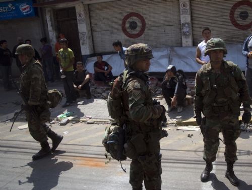 Military forces take under arrest some looters after tsunami and the 8.8-magnitude earthquake in Lota Port, 60km south Concepcion, Chile, March 2, 2010. 