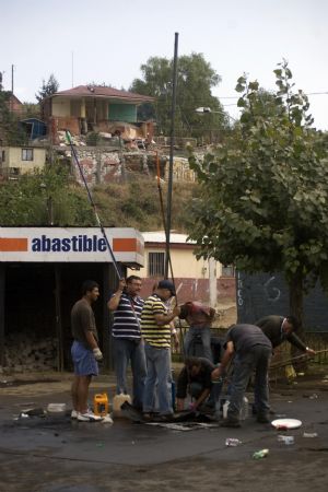People search for oil at a destroyed gas station after tsunami and the 8.8-magnitude earthquake in Lota Port, 60km south Concepcion, Chile, March 2, 2010.