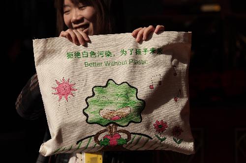 A staff member displays a reusable bag which is handed out to members of the 11th National Committee of the Chinese People's Political Consultative Conference (CPPCC) for carrying meeting materials during the CPPCC session in Beijing, China, March 2, 2010.