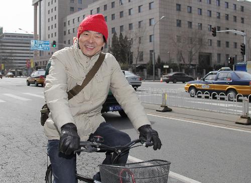 Pu Cunxin, a member of the 11th National Committee of the Chinese People's Political Consultative Conference (CPPCC) and also a famous actor in China, leaves Beijing International Hotel by bicycle after registration for the annual session of CPPCC National Committee in Beijing, China, March 2, 2010. 