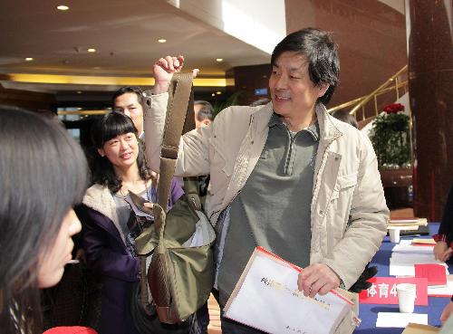 Pu Cunxin (R), a member of the 11th National Committee of the Chinese People's Political Consultative Conference (CPPCC) and also a famous actor in China, registers his arrival for the annual session of CPPCC National Committee at Beijing International Hotel in Beijing, China, March 2, 2010.