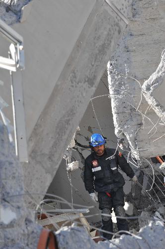 Rescuers are busy on the site of a collapsed building in Concepcion, southern Chile, on March 2, 2010.