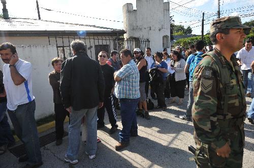 Journalists and locals queue up to apply for curfew pass in Concepcion, southern Chile, on March 2, 2010.