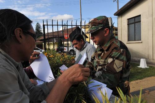 Journalists and locals queue up to apply for curfew pass in Concepcion, southern Chile, on March 2, 2010. 