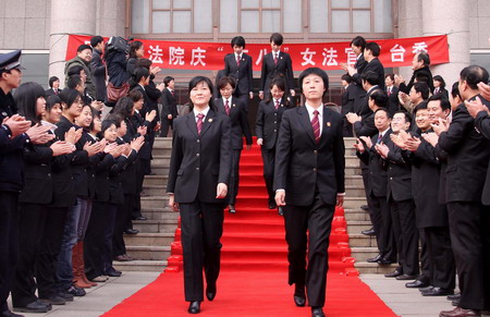 Women judges in uniform walk on the red carpet to celebrate their upcoming festival in Jinan, capital city of east China's Shandong Province, March 4, 2010.