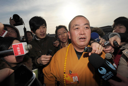 Shi Yongxin, the abbot of Shaolin Temple and a deputy of the NPC, is crowded by reporters in front of the Great Hall of the People, March 5, 2010.
