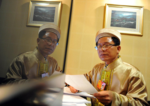 Su Mingfang, an NPC deputy from south China's Guangxi Zhuang autonomous region, prepares his proposals on March 4, 2010.