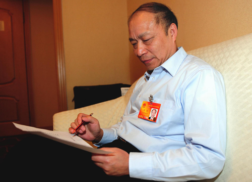 Zhou Meng, a deputy to the NPC and party secretary of Ji'an city in east China's Jiangxi province, fills in a questionnaire about carbon footprints, March 4, 2010. 