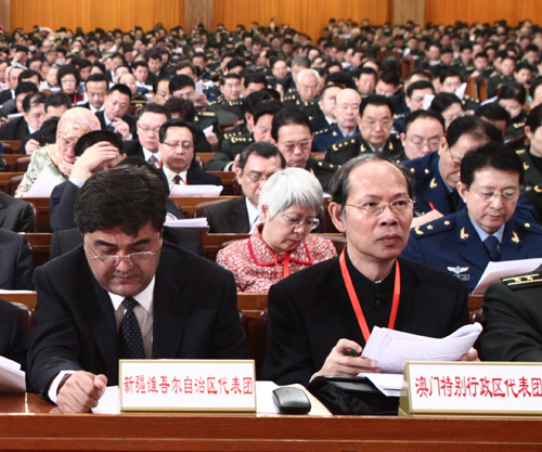 The delegations to the Third Session of the 11th National People&apos;s Congress (NPC) from northwest China&apos;s Xinjiang Uygur Autonomous Region (L) and south China&apos;s Macao Special Administrative Region attend the opening meeting of the Third Session of the 11th NPC at the Great Hall of the People in Beijing, capital of China, March 5, 2010. 