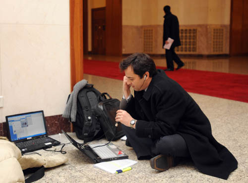 A journalist with BBC works during the opening meeting of the Third Session of the 11th National People's Congress (NPC) at the Great Hall of the People in Beijing, capital of China, March 5, 2010.