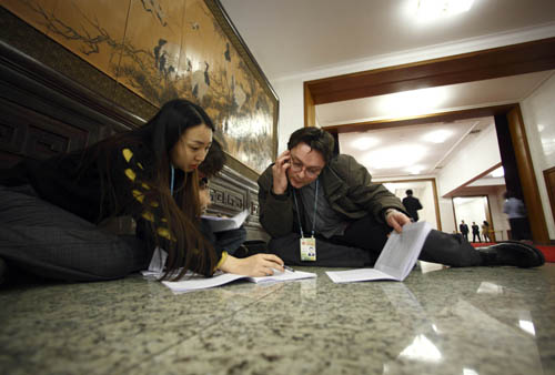 Journalists work prior to the opening meeting of the Third Session of the 11th National People's Congress (NPC) at the Great Hall of the People in Beijing, capital of China, March 5, 2010.