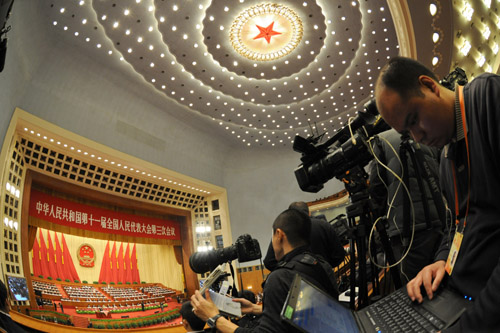 Journalists work during the opening meeting of the Third Session of the 11th National People's Congress (NPC) at the Great Hall of the People in Beijing, capital of China, March 5, 2010.