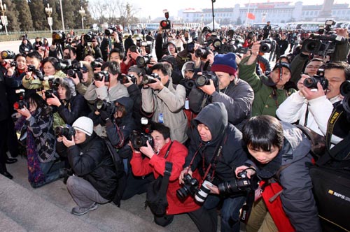 Photographers work prior to the opening meeting of the Third Session of the 11th National People's Congress (NPC) outside the Great Hall of the People in Beijing, capital of China, March 5, 2010.