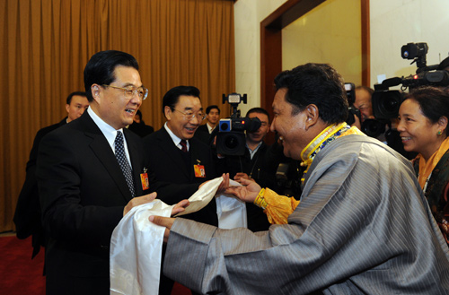 Chinese President Hu Jintao (L, front) receives Hada from a Tibetan deputy when joining a panel discussion with deputies to the Third Session of the 11th National People&apos;s Congress (NPC) from west China&apos;s Tibet Autonomous Region, in Beijing, capital of China, March 6, 2010.