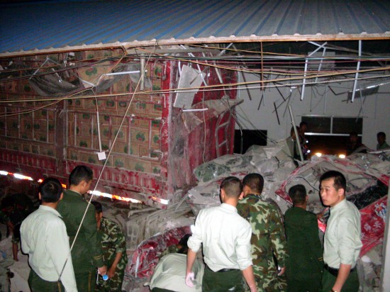 Chinese paramilitary policemen examine the crash site of a cargo truck carrying boxes of watermelons in Baoshan, South China's Yunnan Province, March 7, 2010. 