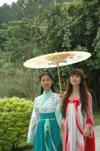 Young girls in traditional Chinese clothes enjoy a moment as they tour in a forest park in Fogang county, south China's Guangdong Province, March 7, 2010. 