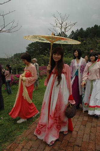Young girls in traditional Chinese clothes enjoy a moment as they tour in a forest park in Fogang county, south China's Guangdong Province, March 7, 2010. 