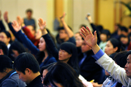 Reporters raise hands to ask questions at a press conference on the sidelines of an ongoing session of the National People's Congress, the top legislature, in Beijing, March 7, 2010. 