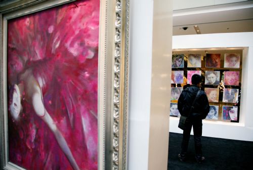 A local citizen admires an exhibition on female portrait oil painting works at downtown Nanjing, east China's Jiangsu Province, March 7, 2010.