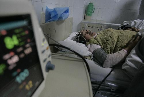 Wang Xiumeng, injured in the head after a collapse of floor slabs at a local demolition site, receives treatment at a hospital in Wuhan, capital of central China&apos;s Hubei Province, March 8, 2010.