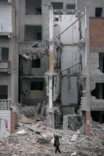 A man walks on the debris after a collapse of floor slabs at a demolition site in Wuhan, capital of central China&apos;s Hubei Province, March 8, 2010.