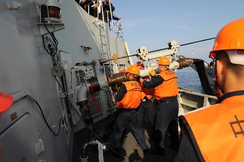 Crew members of China's missile destroyer 'Guangzhou' install the refueling pipe sent from 'Weishanhu' supply ship during the task of replenishment in the Indian Ocean, March 9, 2010. 