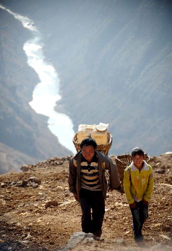 Villagers carry water back home from down the mountain in Huize County of Qujing City, southwest China's Yunnan Province, on March 7, 2010. 