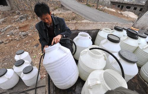 Wang Fu, a villager of Ketuo Village, unloads water that he transported from 5 kilometers away, in Puding County, southwest China's Guizhou Province, March 9, 2010. 