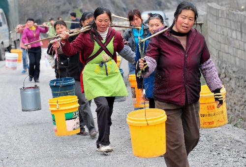 Villagers of Ketuo Village carry water from a cave one kilometer away in Puding County, southwest China's Guizhou Province, March 9, 2010.