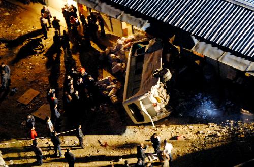 People gather at the site of a bus accident near Shanshulin Bridge between Longli and Guiyang, capital of southwest China's Guizhou Province, March 10, 2010.