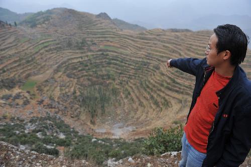 A village official points to an area where the severe drought occurred in Panxian, southwest China's Guizhou Province, on March 10, 2010.