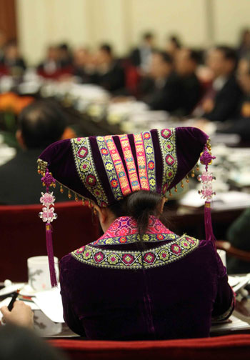 A deputy of Zhuang ethnic group to the Third Session of the National People&apos;s Congress (NPC) from southwest China&apos;s Guangxi Zhuang Autonomous Region takes notes during a panel discussion on the work report of the Standing Committee of the NPC in Beijing, China, March 10, 2010. 