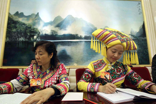 Huang Rumei (L) and Xiang Huiling, deputies of Zhuang ethnic group to the Third Session of the National People&apos;s Congress (NPC) from southwest China&apos;s Guangxi Zhuang Autonomous Region, take notes during a panel discussion on the work report of the Standing Committee of the NPC in Beijing, China, March 10, 2010.
